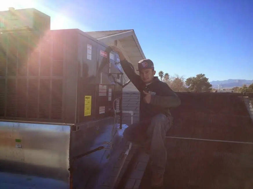 HVAC technician performing Heat Pump Repair on a rooftop unit in San Tan Valley